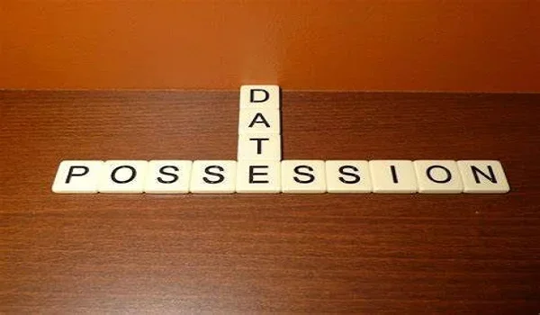 Letter tiles spelling Possession Date on a wooden desk