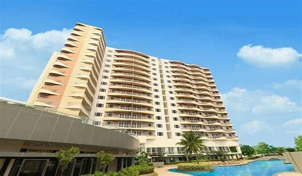 Curved residential tower beside a swimming pool, representing development near the tech corridor